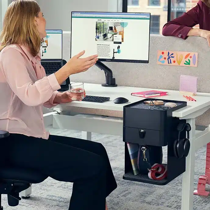 Büromöbel - Bürodesign Angerer - Zwei Frauen im Büro mit Computern an Schreibtischen in entspannter Unterhaltung – Salzburg - Berchtesgadener Land